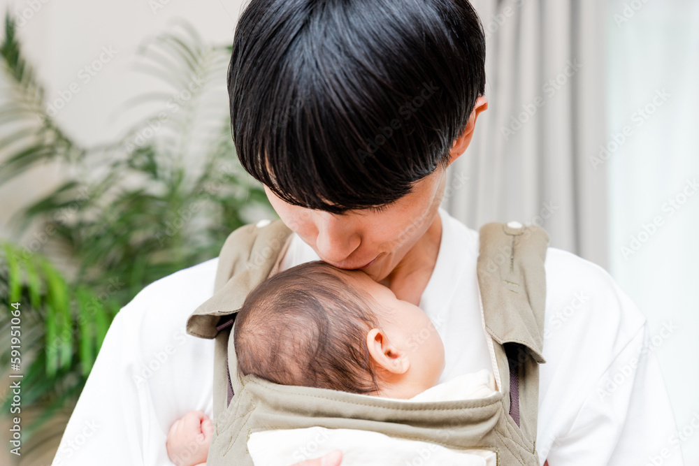リビングで0歳の赤ちゃんを抱っこして寝かしつける20代〜30代の父親の男性 リビングで0歳の赤ちゃんを抱っこして寝かしつける20代〜30代の父親の男性