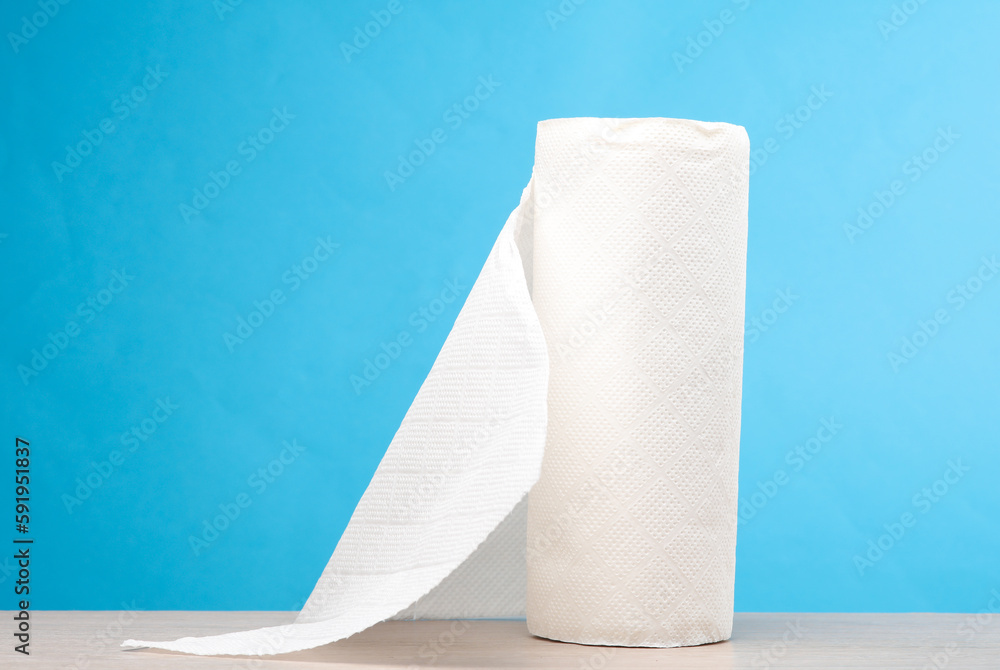 Roll of white paper towels on the table, blue background Roll of white paper towels on the table, blue background
