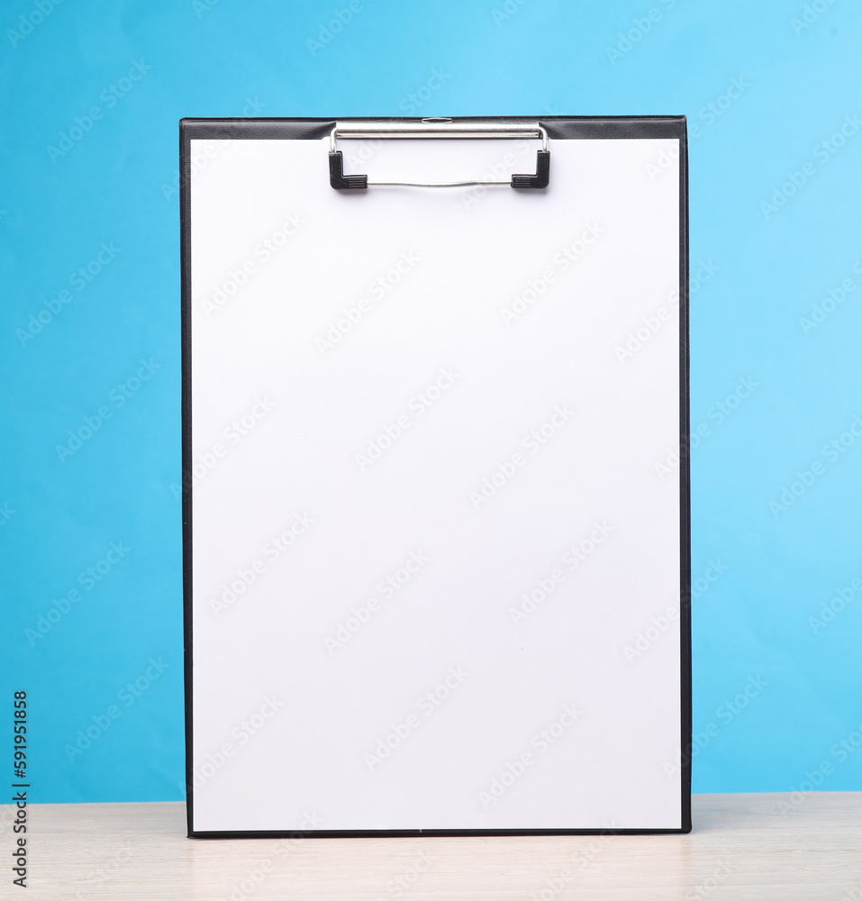 White empty clipboard on the table, blue background. Template for design White empty clipboard on the table, blue background. Template for design