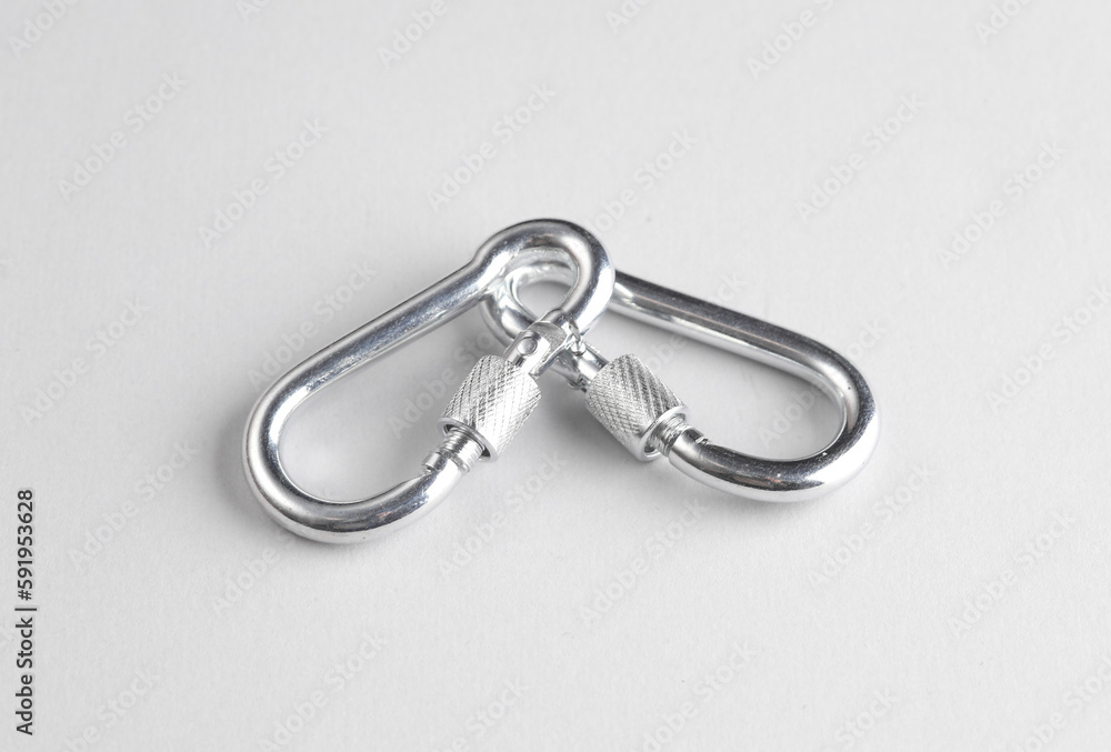 Two metal carabiners on a gray background Two metal carabiners on a gray background