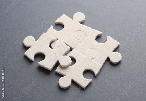 White jigsaw puzzle pieces on dark background.