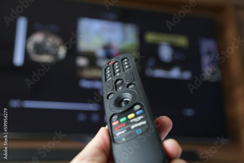 Controle de tv na mão de uma pessoa apontada para abrir o canal Streaming.