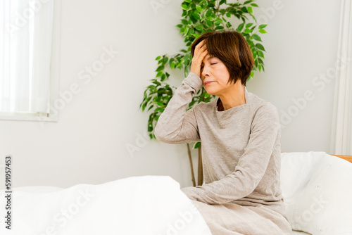 Bild auf Leinwand 寝起きで頭を抱える50代から60代の女性