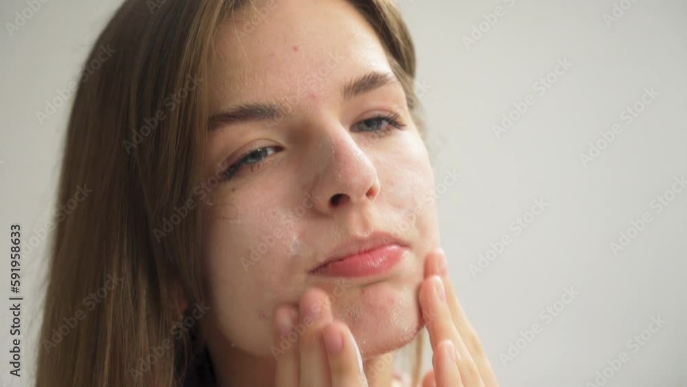 Beautiful young woman washing clean face with water and smiling in front of the mirror in the bathroom. Beautiful young woman washing clean face with water and smiling in front of the mirror in the bathroom.