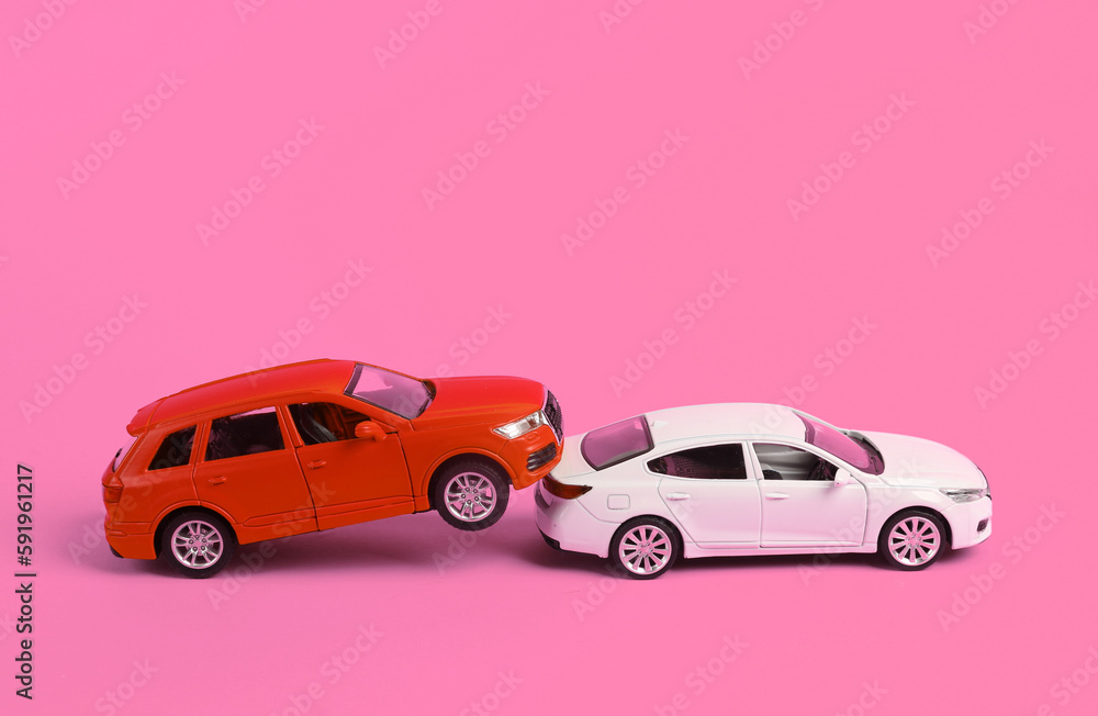 Two mini toy car crash on pink background, incident, car traffic accident
