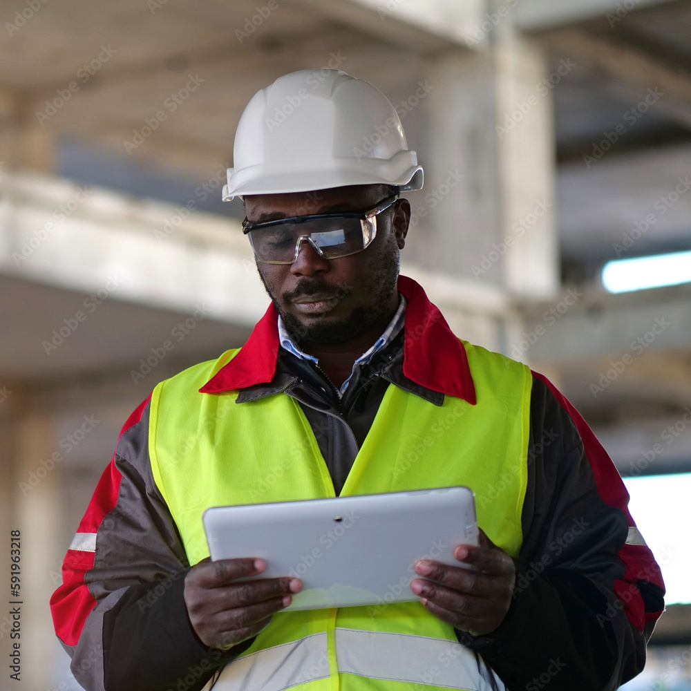 African american worker holds in hands tablet computer and looks at camera