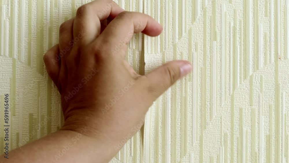 Stockvideon Human hand rip off old yellow wallpaper from wall over