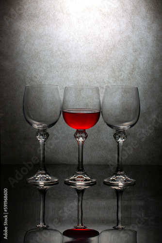 Still life with three glasses of red liquid