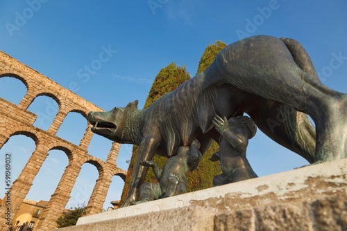 Statue Of A She-Wolf Suckling Romulus And Remus With The Roman Aqueduct In The Background; Segovia, Segovia Province, Spain photo