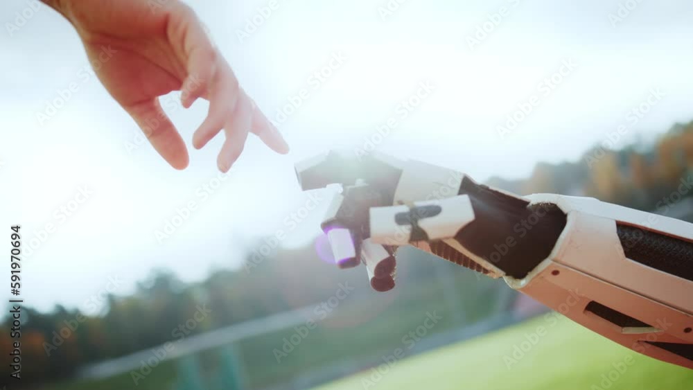 Horizontal view of robot arm and human hand pointing fingertips on ...