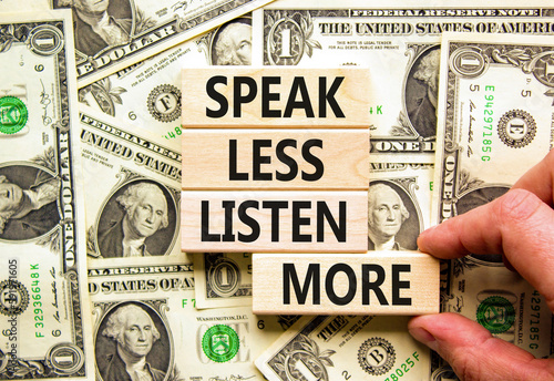 Speak less listen more symbol. Concept words Speak less listen more on wooden block. Beautiful background from dollar bills. Motivational business speak less listen more concept. Copy space.
