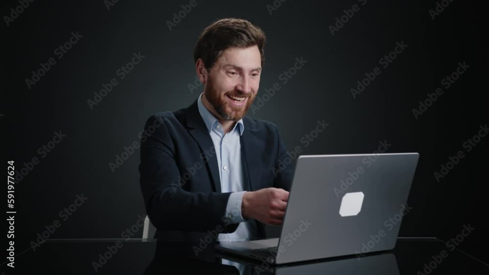 A man in a black suit working and pulling out a stack of money out of the laptop. He looks happy. He is in a black room. High quality 4k footage A man in a black suit working and pulling out a stack of money out of the laptop. He looks happy. He is in a black room. High quality 4k footage