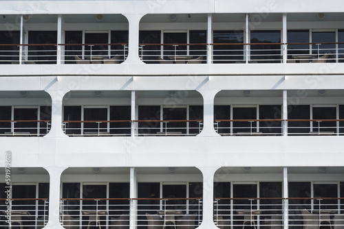 Three levels on the side of a boat with chairs on the balconies and glass walls; Kotor, Opstina Kotor, Montenegro photo