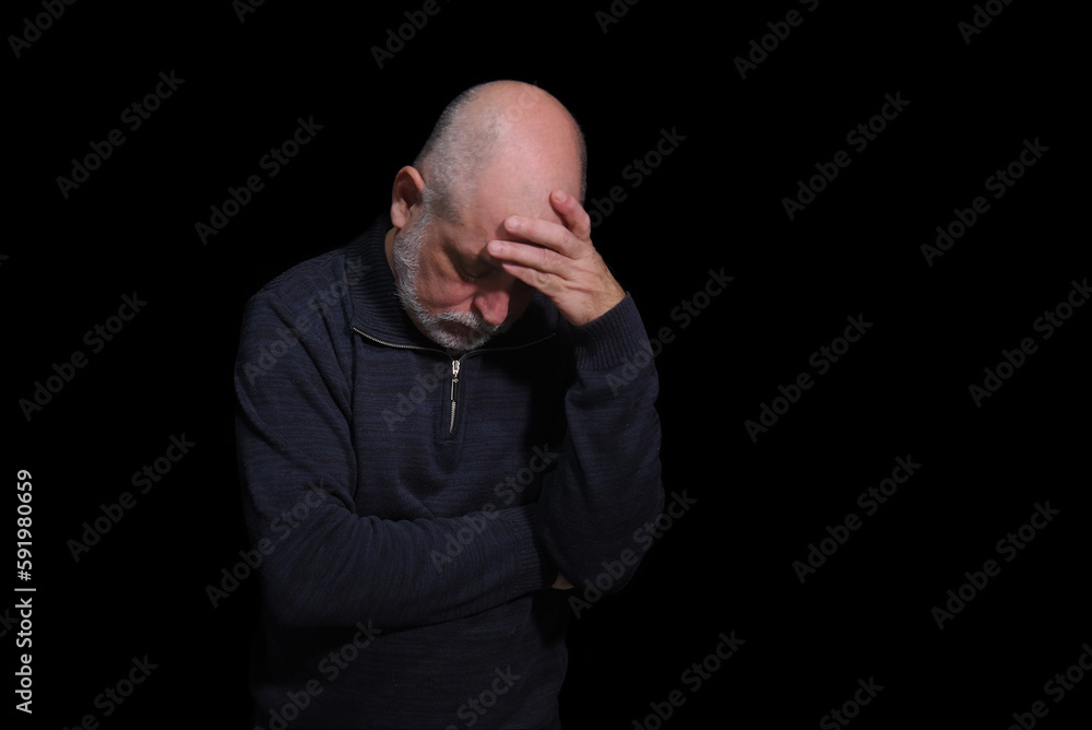 portrait of older bearded man pensive and watching isolated on black background