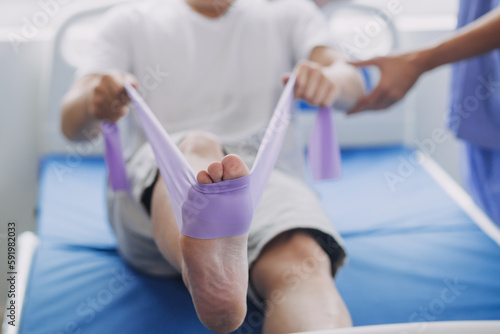 Doctor or Physiotherapist working examining treating injured arm of athlete male patient, stretching and exercise, Doing the Rehabilitation therapy pain in clinic.