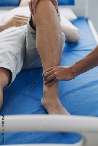 Doctor or Physiotherapist working examining treating injured arm of athlete male patient, stretching and exercise, Doing the Rehabilitation therapy pain in clinic. © Sirikarn Rinruesee
