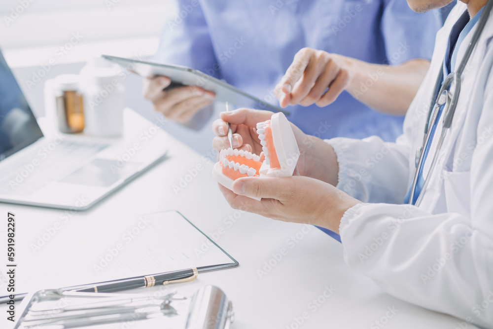 Dentists are discussing dental problems at report x-ray image on laptop screen to patients. Dentists are discussing dental problems at report x-ray image on laptop screen to patients.