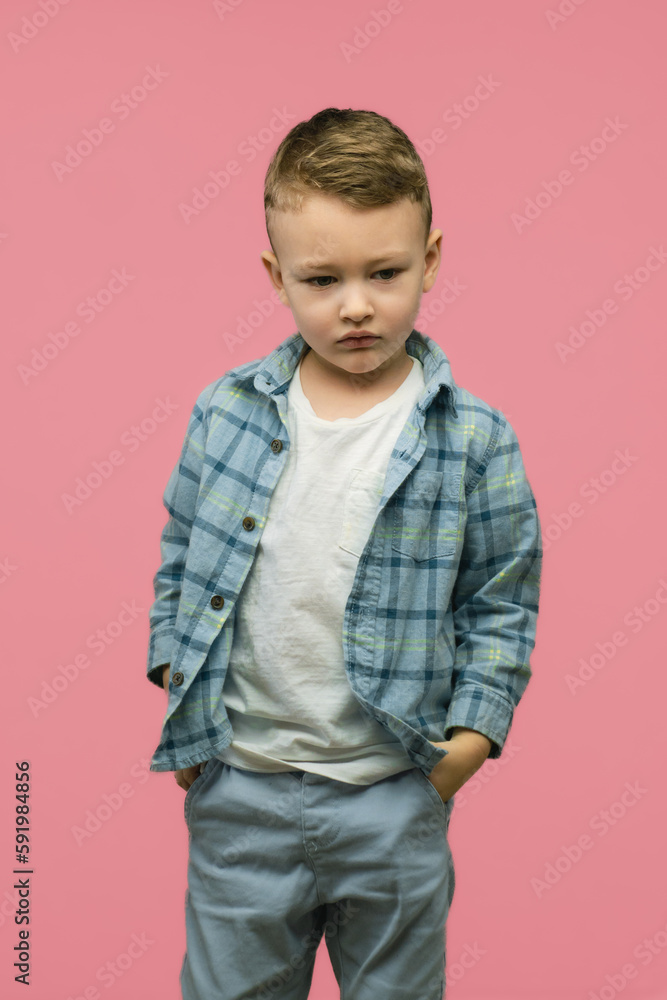 Sad kid posing on pink background. Vertical photo. Sad kid posing on pink background. Vertical photo.
