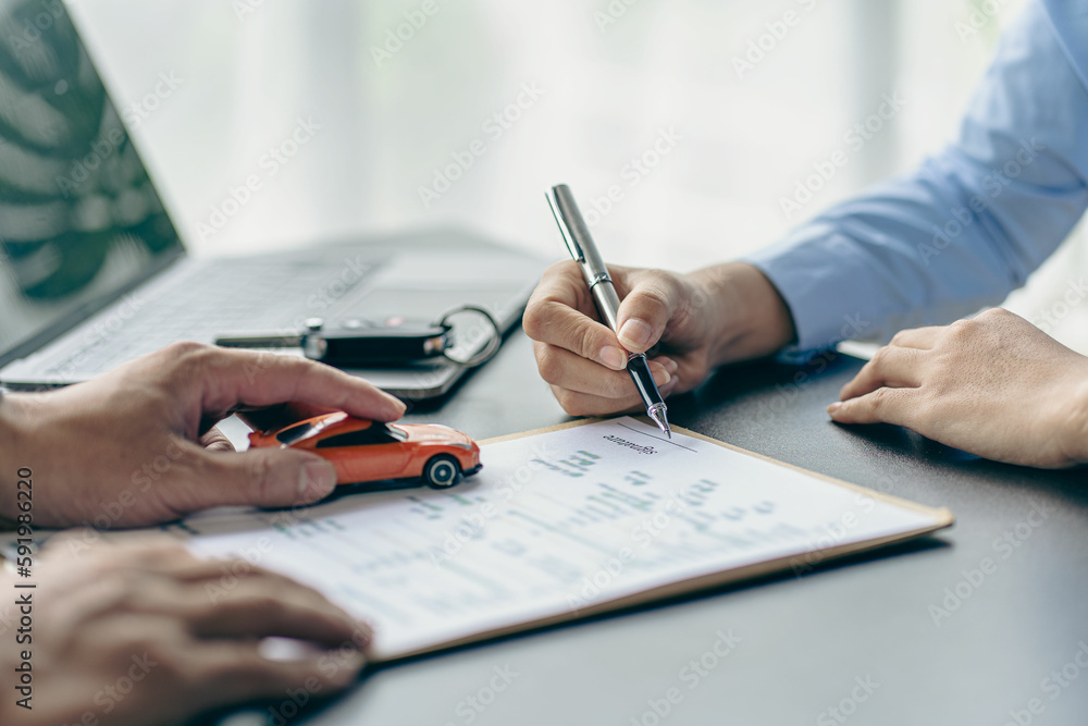 Naklejka premium Salesman guiding customer seated at table. Car business. Car sale. Dealership closing. and the new owner has entered into a contract The idea of ​​selling and renting a car with insurance.