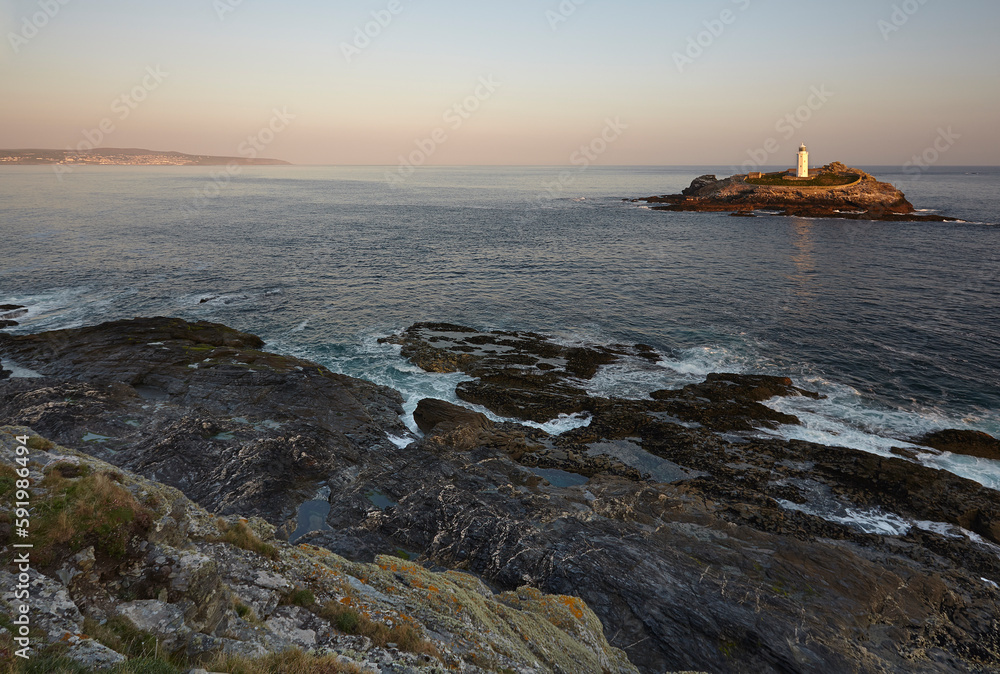 Godrevy Lighthouse on Godrevy Island seen from the rocky cliffs at the