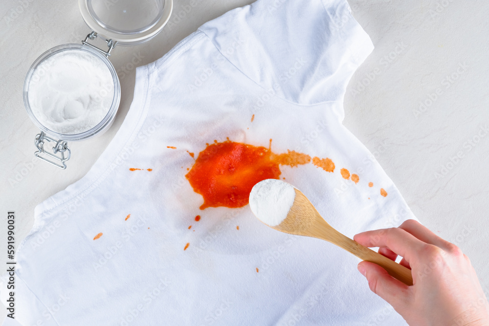 a-female-s-hand-removing-stain-on-clothes-with-baking-soda-top-view