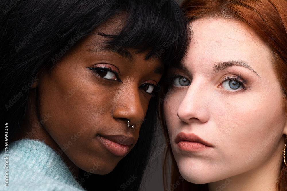 Very close portrait of the faces of two different ethnic girls