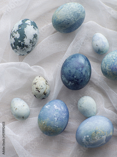 Blue painted easter eggs. Dyed Easter eggs with marble stone effect blue color on white tablecloth background. Eggs background with copy space, Ester holiday postcard concept.