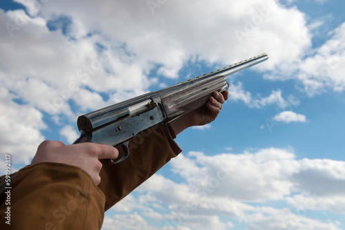 Close-up of a person aiming a rifle at the sky; Bennet, Nebraska, United States of America photo
