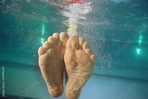 Close-up view of wrinkled feet underwater in a swimming pool; Nebraska, United States of America