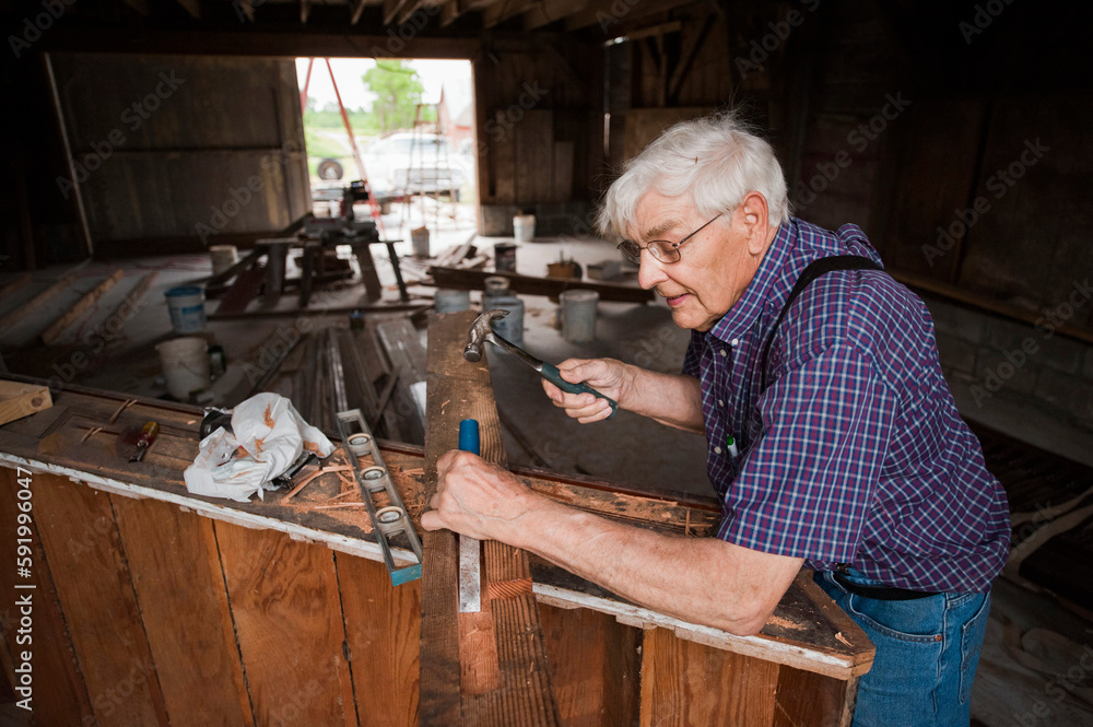 Senior man works to install a staircase; Dunbar, Nebraska, United States of America Senior man works to install a staircase; Dunbar, Nebraska, United States of America