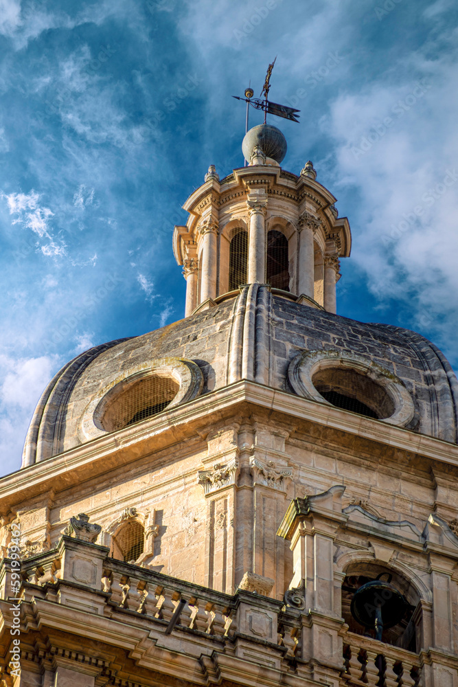 Detail of the bell tower of the Cathedral of Murcia, Spain in neoclassical style and intense blue sky with clouds