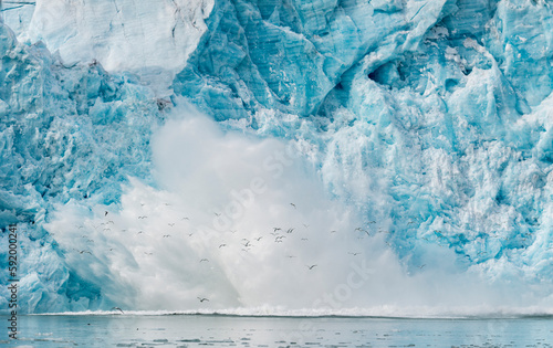 Water spray explodes after ice from the Monacobreen Glacier crashes into the sea; Norway photo