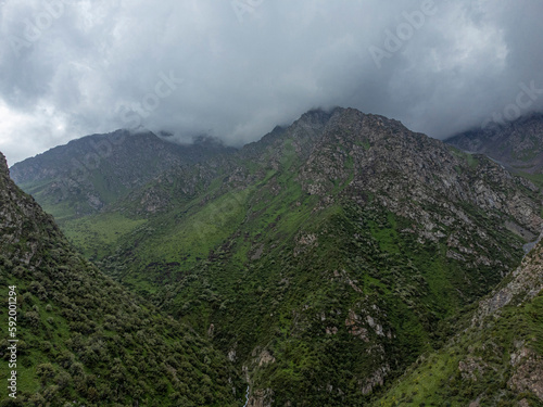 Aerial view flying through cloud covered mountains in Alamedin Gorge, Kyrgyzstan.