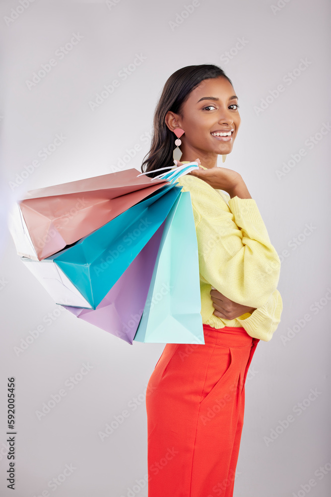 Portrait, shopping and sales with a woman customer in studio on a gray background for retail or consumerism. Fashion, luxury or smile with an attractive young female carrying bags over her shoulder Portrait, shopping and sales with a woman customer in studio on a gray background for retail or consumerism. Fashion, luxury or smile with an attractive young female carrying bags over her shoulder