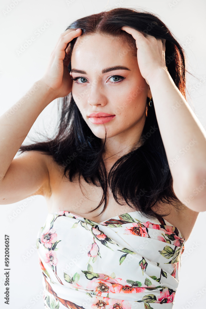 portrait of a beautiful woman in a floral dress in a bright room portrait of a beautiful woman in a floral dress in a bright room