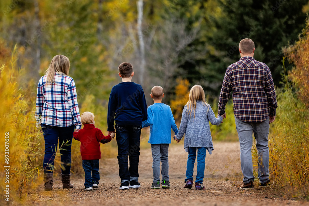 Family of six walking together hand in hand in a park in autumn; Edmonton, Alberta, Canada Family of six walking together hand in hand in a park in autumn; Edmonton, Alberta, Canada