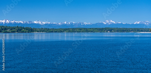 Olympic Mountains as seen on a clear Summer day about 45 miles from the middle of Budd Inlet in the Puget Sound near Olympia, Washington, USA; Washington, United States of America photo