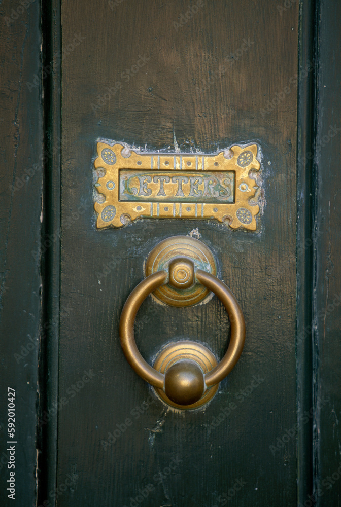 Close view of an old door knocker and mail slot on a wooden door; Newport, Rhode Island, United States of America Close view of an old door knocker and mail slot on a wooden door; Newport, Rhode Island, United States of America