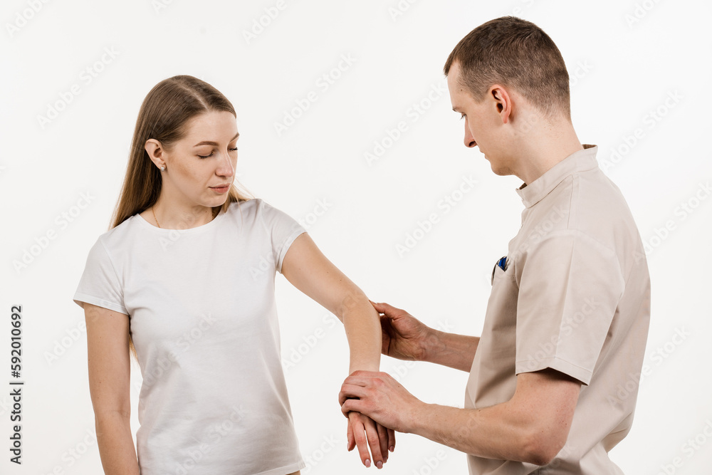 Tennis elbow, or lateral epicondylitis is painful condition of the elbow joint caused by overuse. Orthopedist traumatologist examines elbow joint with pain and prescribes treatment for girl patient. Tennis elbow, or lateral epicondylitis is painful condition of the elbow joint caused by overuse. Orthopedist traumatologist examines elbow joint with pain and prescribes treatment for girl patient.