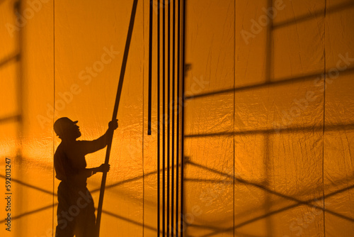 Silhouette of a construction worker holding a pole; United States of America photo