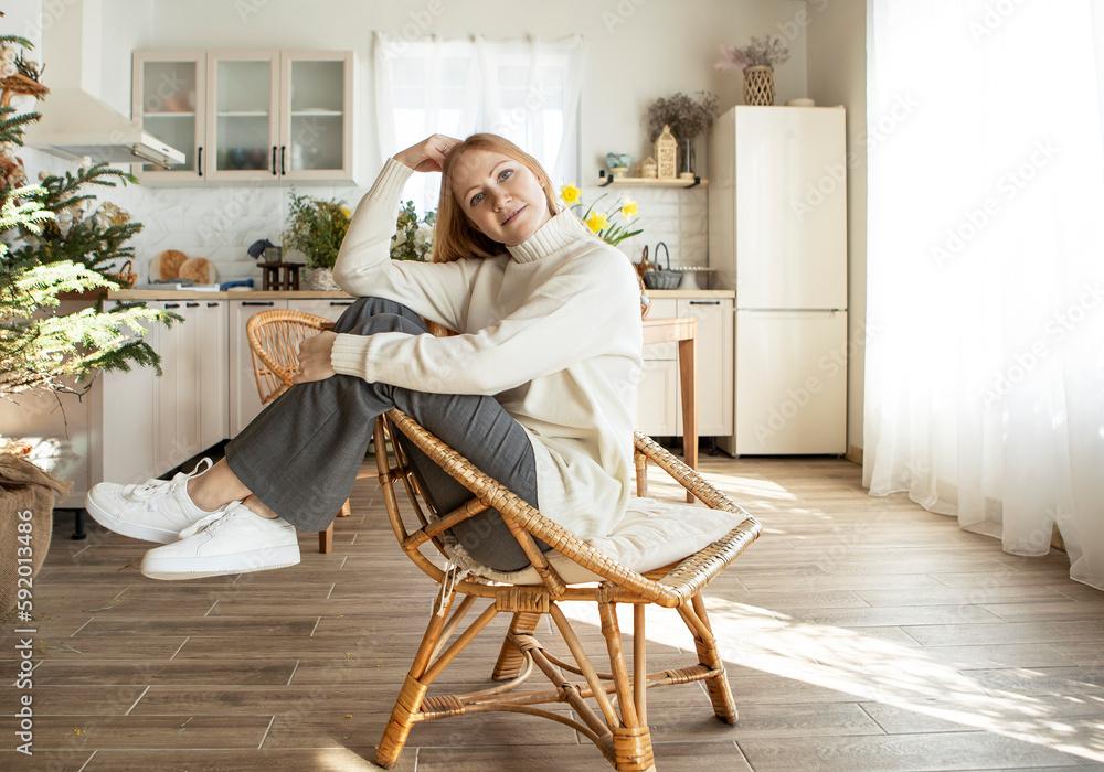 portrait of a girl with long red hair in a white sweater at home