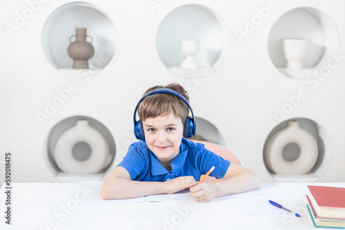 Cute school boy studying online at home. Distance learning and online education concept	