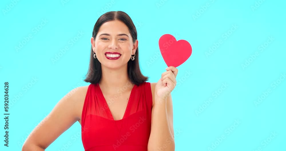 Paper heart, happy woman and face on blue background, studio and backdrop. Portrait of female model in red dress with shape of love, trust and romance for valentines day, flirting and elegant smile Paper heart, happy woman and face on blue background, studio and backdrop. Portrait of female model in red dress with shape of love, trust and romance for valentines day, flirting and elegant smile