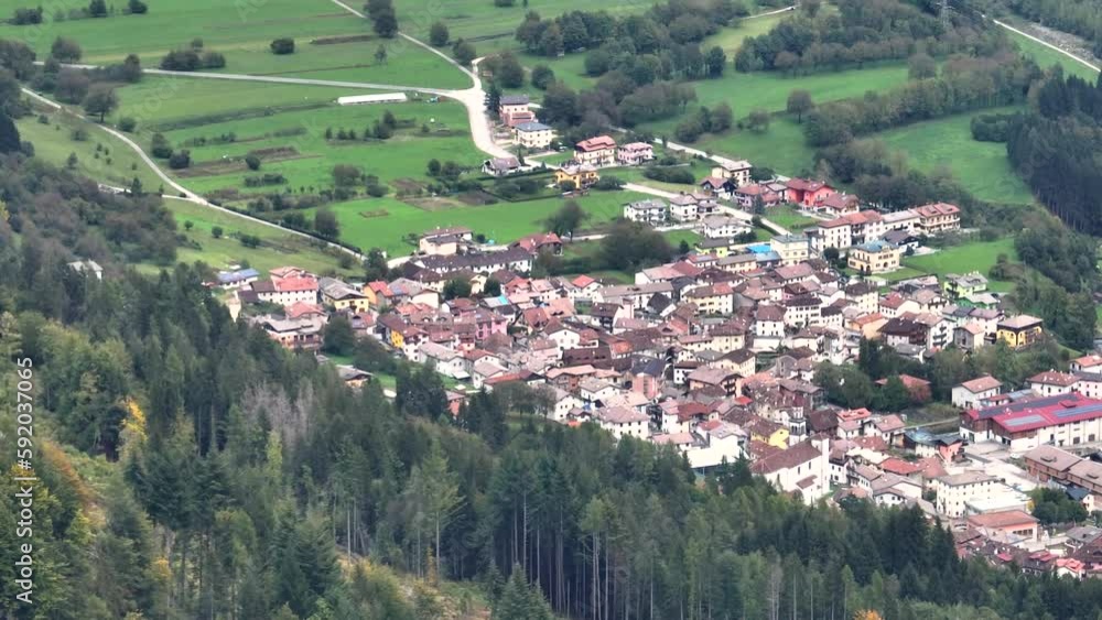 OVARO MIONE, ITALY - APRIL, 2023: Aerial drone view of a valley in the morning with clouds. Small mauntain village Mione with beautiful houses on the green slopes of the Italian Alps. OVARO MIONE, ITALY - APRIL, 2023: Aerial drone view of a valley in the morning with clouds. Small mauntain village Mione with beautiful houses on the green slopes of the Italian Alps.