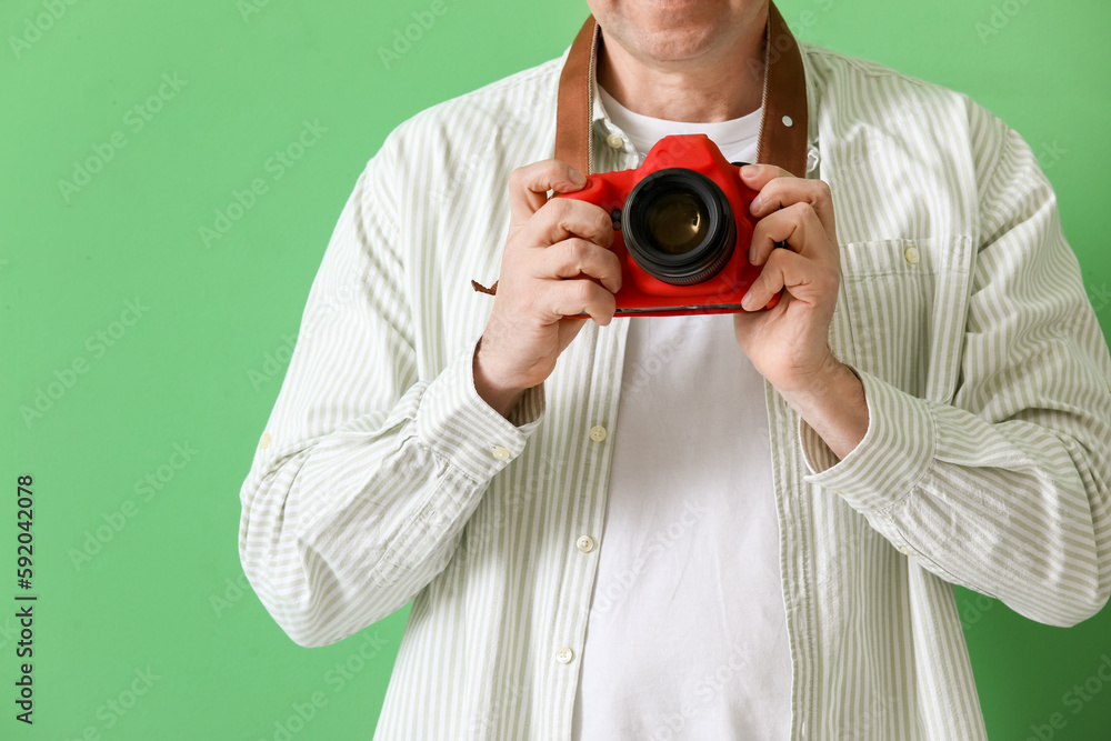 Mature photographer with professional camera on green background, closeup Mature photographer with professional camera on green background, closeup