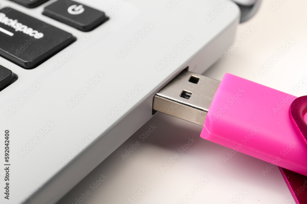 Laptop with pink USB flash drive isolated on white background Laptop with pink USB flash drive isolated on white background