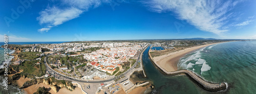 Aerial of Lagos Portugal views of Praia do Camilo and lighthouse at sunrise. Beautiful natural beaches and cliffs