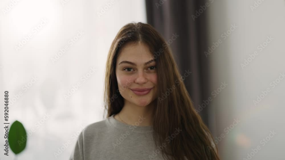 Confident smiling woman looking at camera standing at home Confident smiling woman looking at camera standing at home
