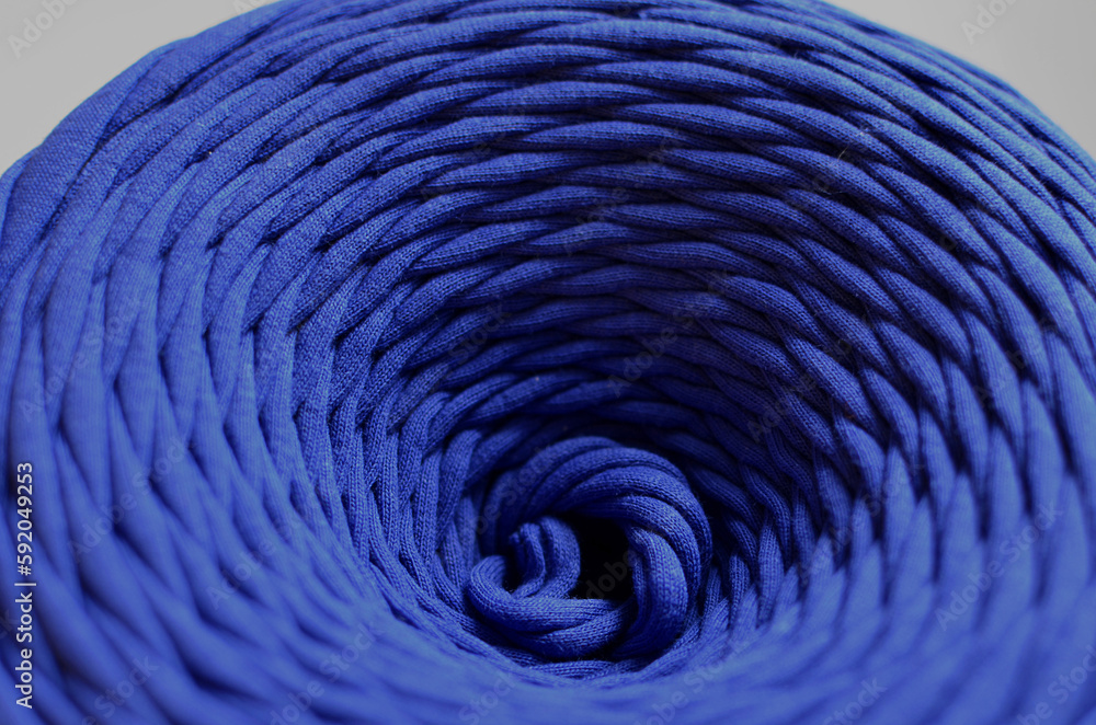 Bobbin of knitted yarn for crocheting bags, blue abstract background with circular structure, like a funnel Bobbin of knitted yarn for crocheting bags, blue abstract background with circular structure, like a funnel