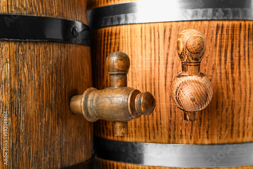 Oak barrels with taps and metal hoops as background, closeup